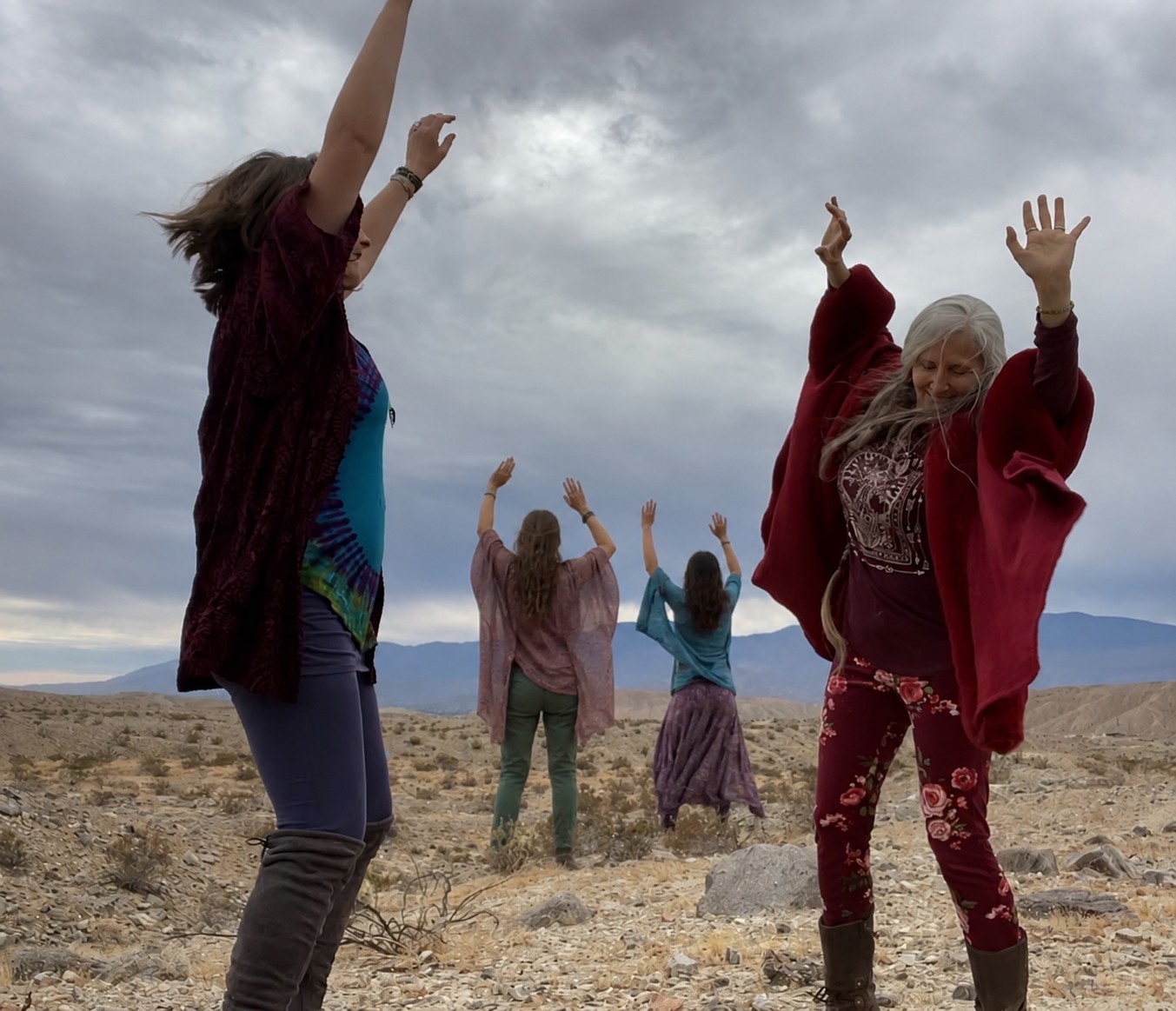 Women dancing together in the desert