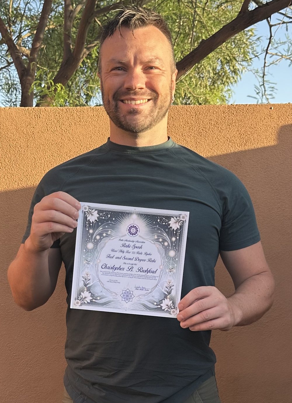 Christopher Rushford holding his First and Second Degree certificate